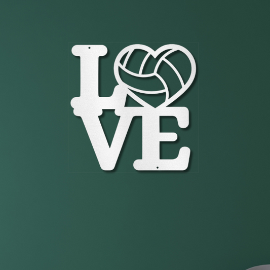 Decorative white metal wall art with 'LOVE' and a volleyball design on a green wall.