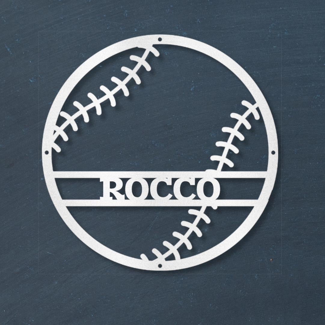 White baseball-shaped wall decal with 'ROCCO' text on a dark blue wall.