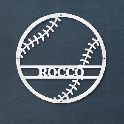 White baseball-shaped wall decal with 'ROCCO' text on a dark blue wall.