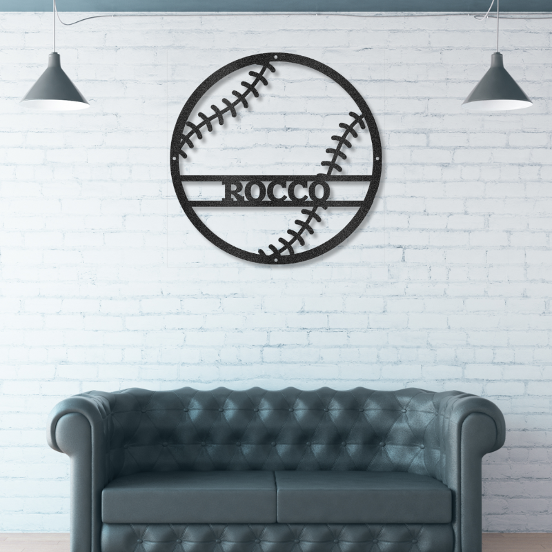 Decorative metal wall art of a baseball personalized with an athlete's name on a white brick wall above a gray sofa.