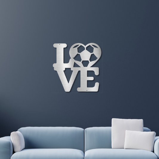 Silver metal "LOVE" wall art with a soccer ball heart shaped "O" on a dark blue wall
